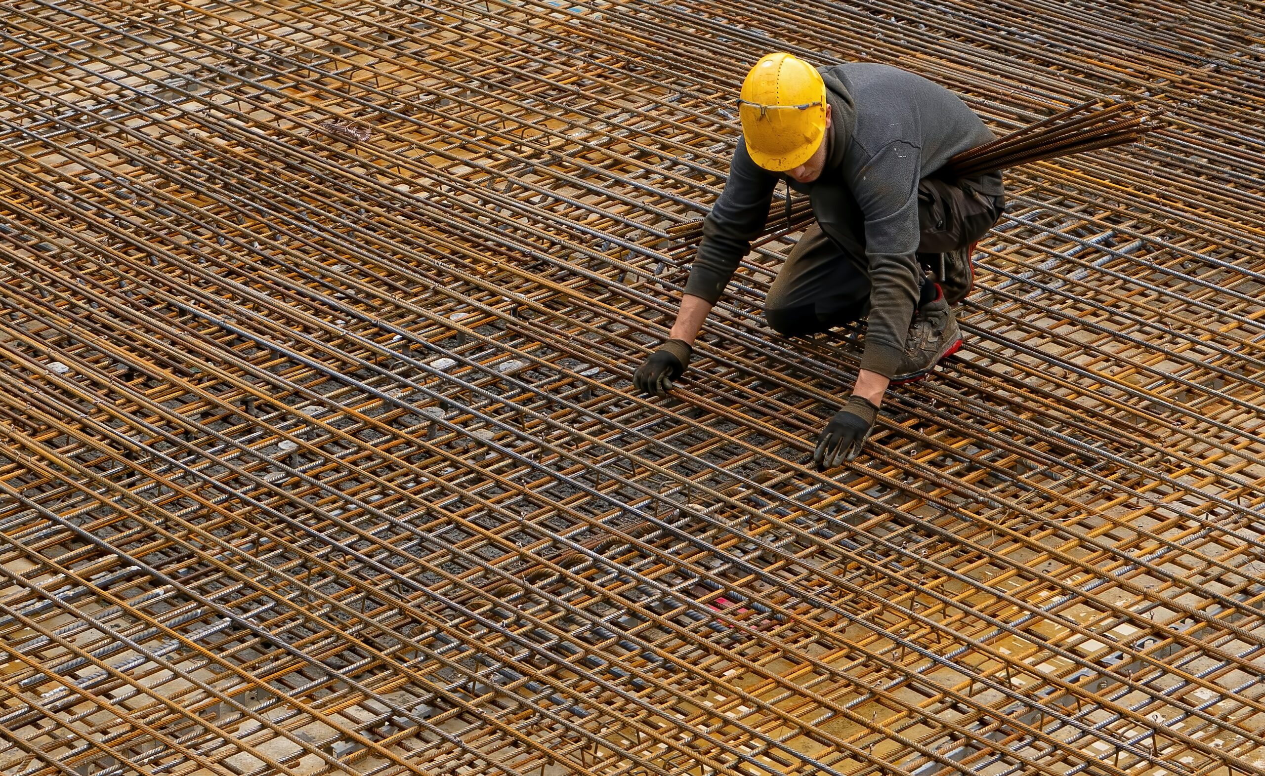 Trabalhador em cima de grades de ferro